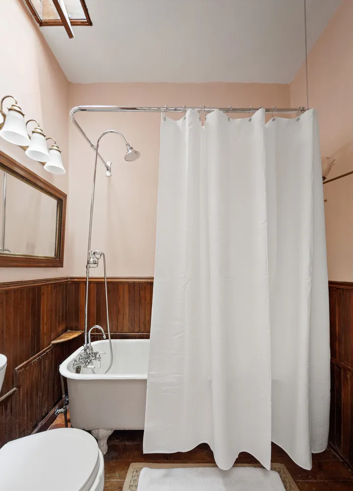 a view of a hallway with wooden floor and furniture