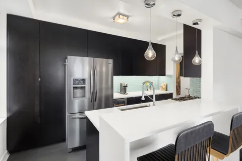 a kitchen with a table and refrigerator