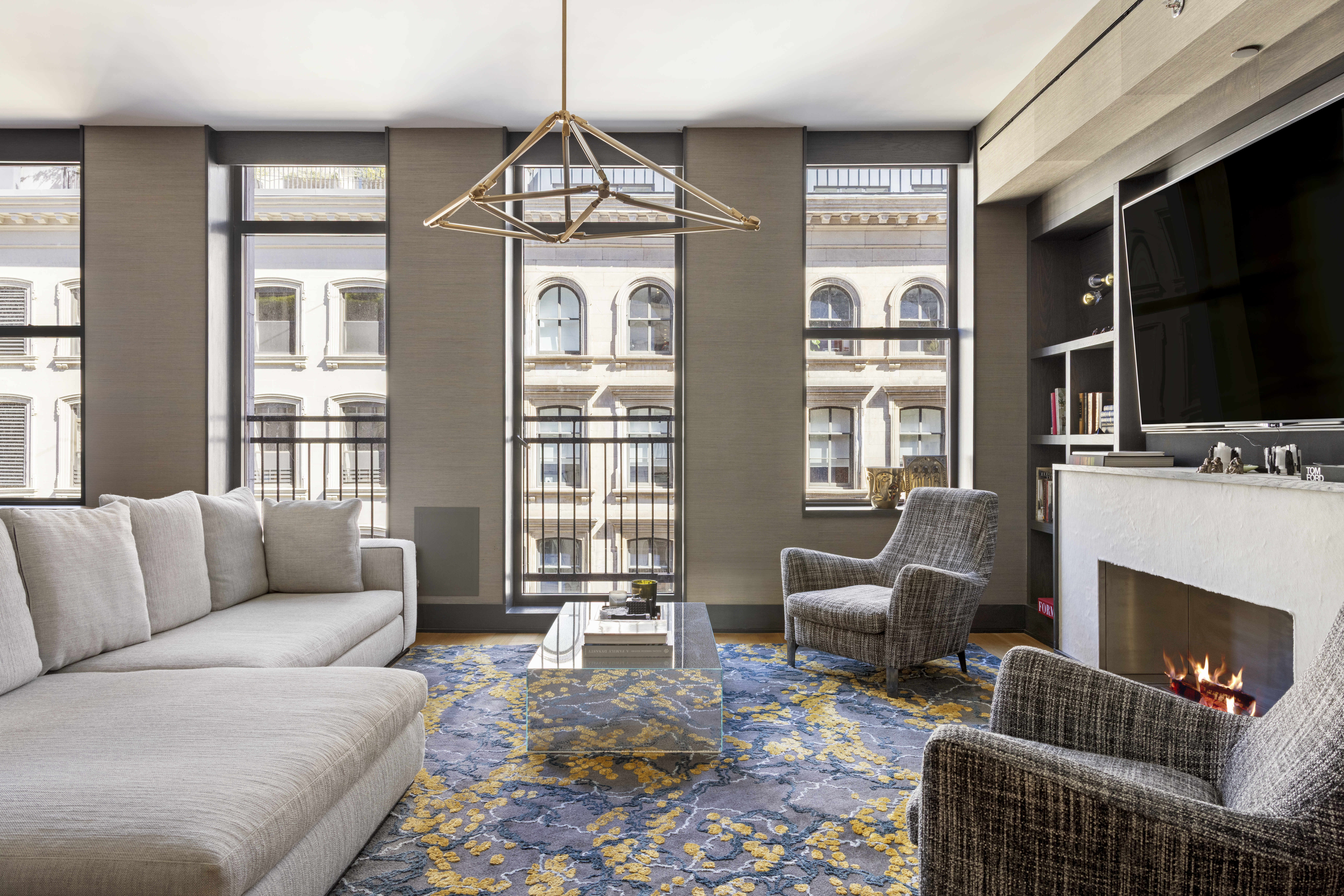 71 Reade Street, Unit 5A Manhattan, NY 10007 - Photo 3 of 27 a living room with furniture a flat screen tv and a fireplace