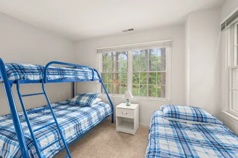 a bedroom with a bed a rug and a window