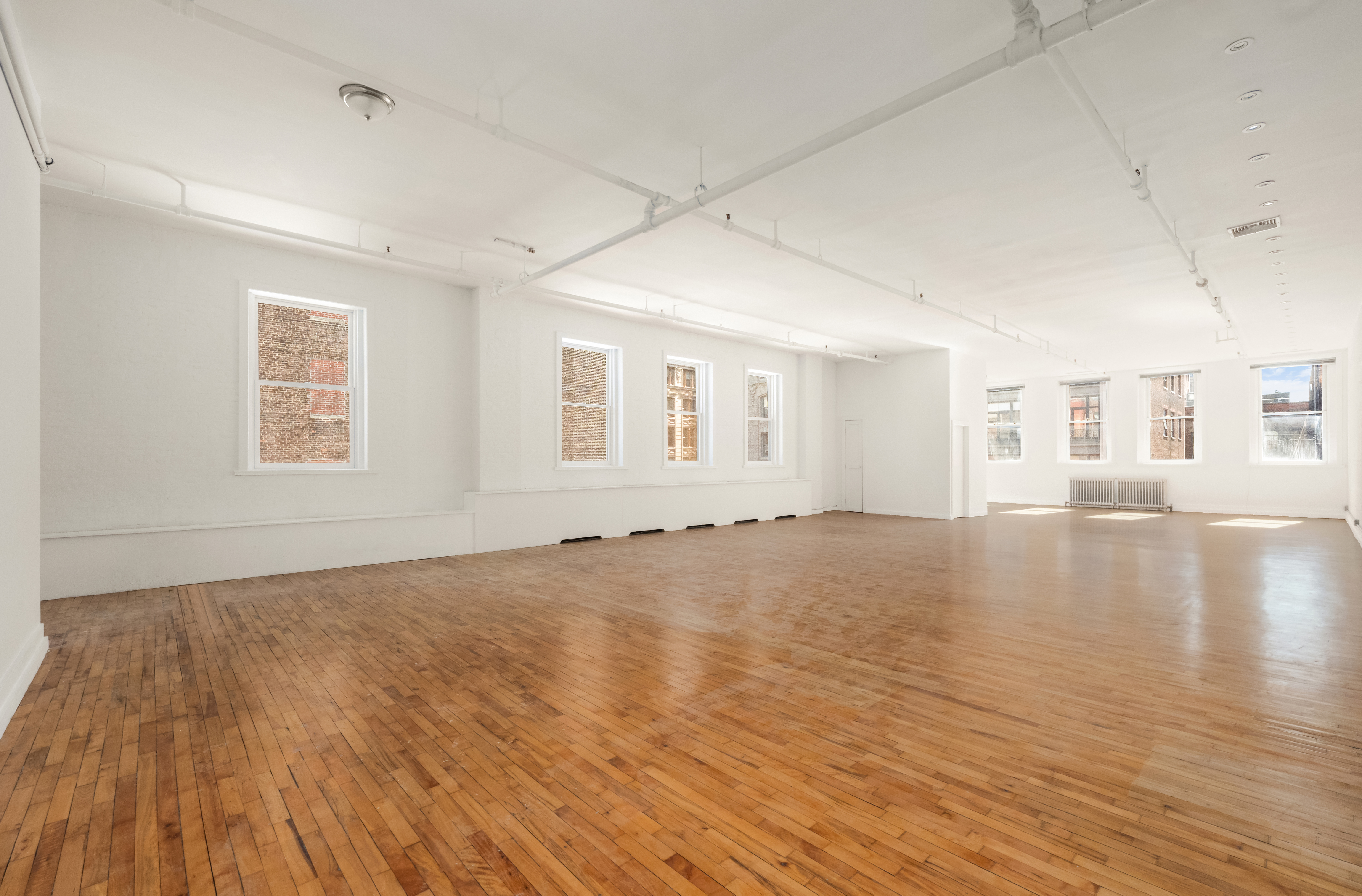519 Broadway, Unit PHC Manhattan, NY 10012 - Photo 2 of 16 a view of empty room with wooden floor and fan