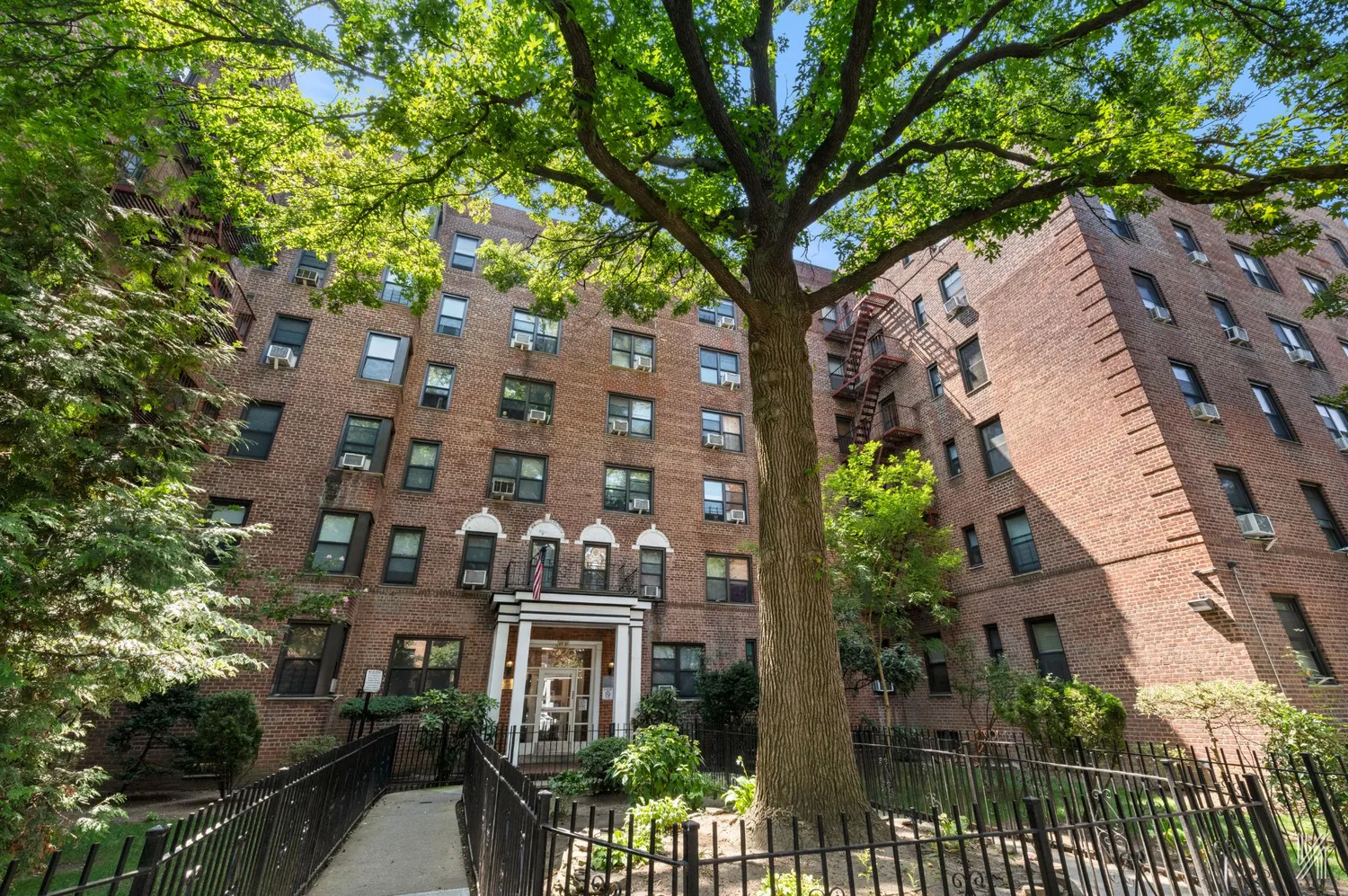 an aerial view of a residential apartment building with a tree