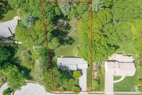 an aerial view of a house with a yard basket ball court and outdoor seating