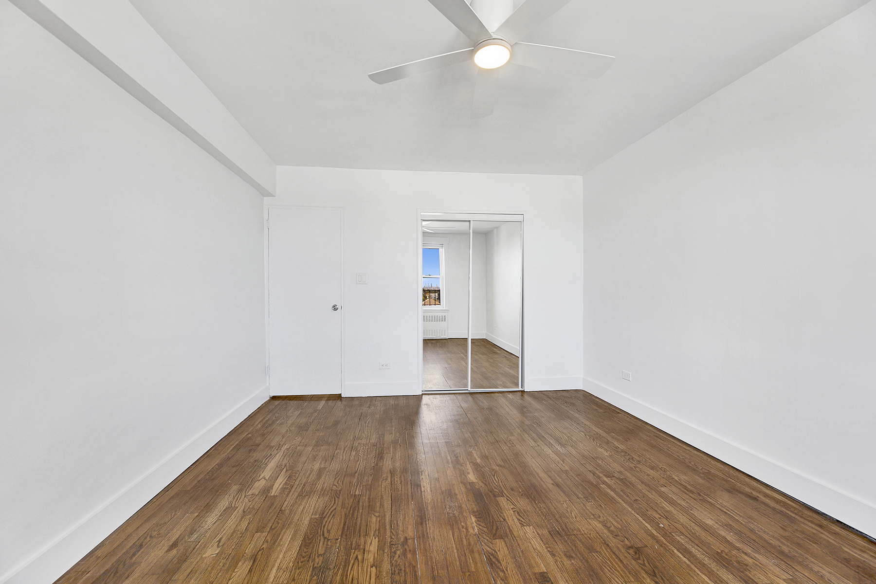 125 Beach 124th Street, Unit 5K Queens, NY 11694 - Photo 15 of 21 an empty room with wooden floor and windows