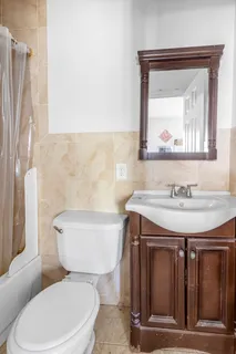 a bathroom with a granite countertop toilet sink and mirror