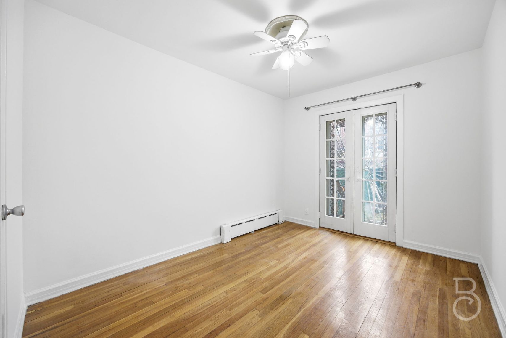 22-61 46th Street Queens, NY 11105 - Photo 21 of 24 an empty room with wooden floor fan and windows