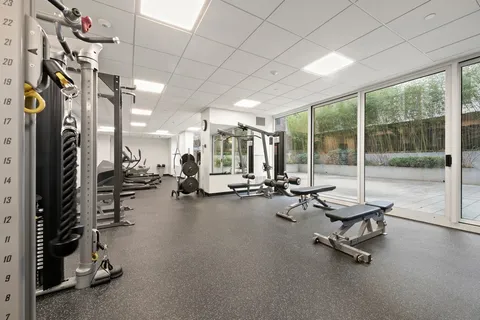 a room with gym equipment and large mirror