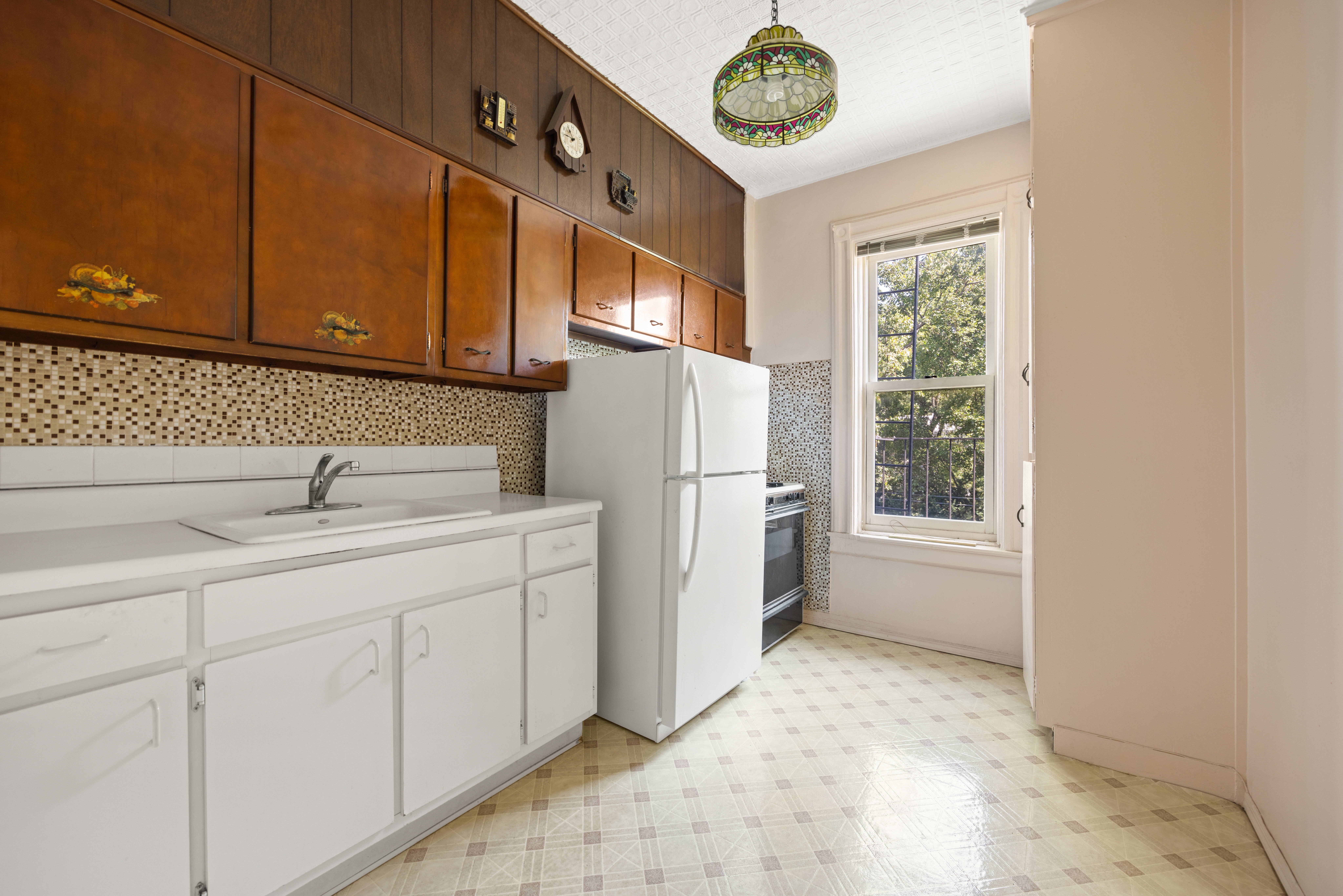 273 Windsor Place Brooklyn, NY 11218 - Photo 25 of 29 a kitchen with white cabinets and a refrigerator