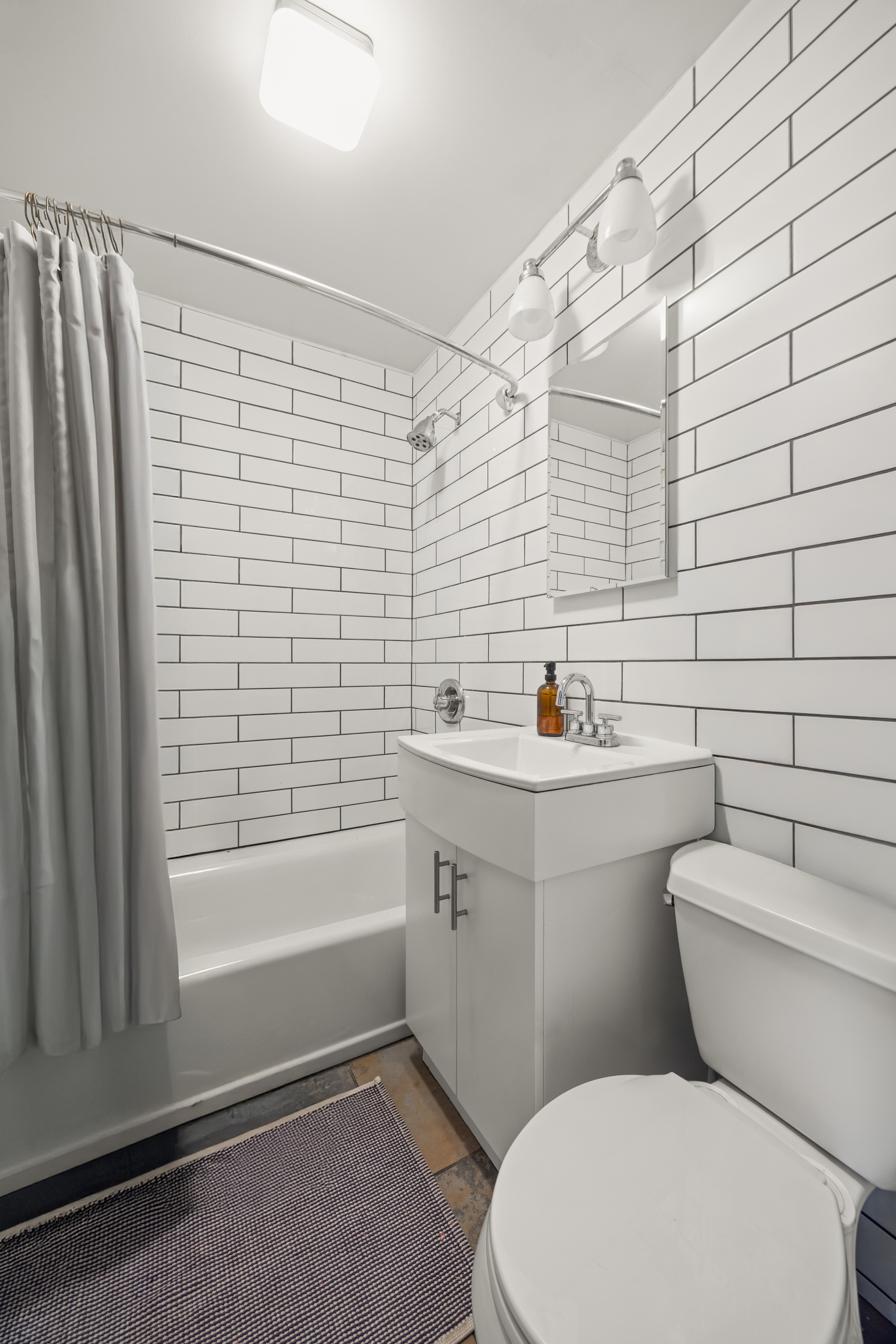 44 Turner Place, Unit 2 Brooklyn, NY 11218 - Photo 8 of 9 a bathroom with a toilet a sink a mirror and shower