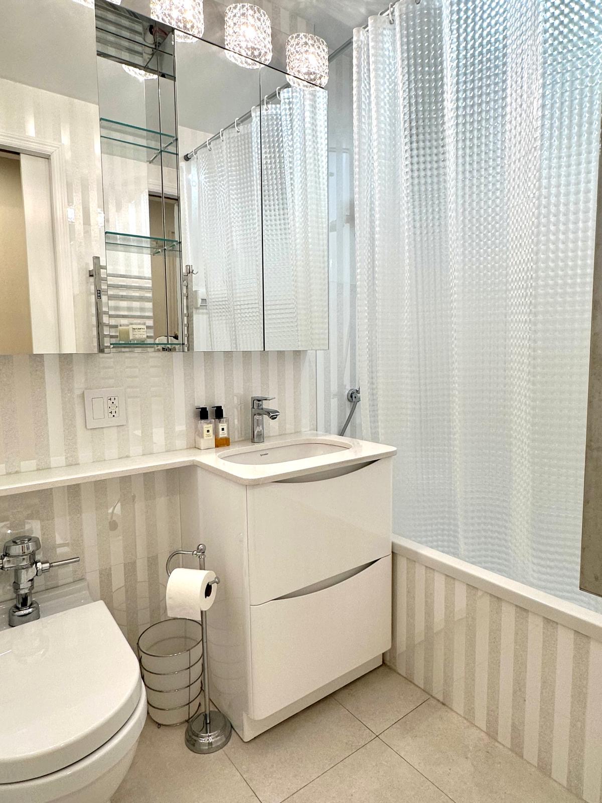 309 East 87th Street, Unit 3L Manhattan, NY 10128 - Photo 7 of 14 a bathroom with a sink a toilet and vanity