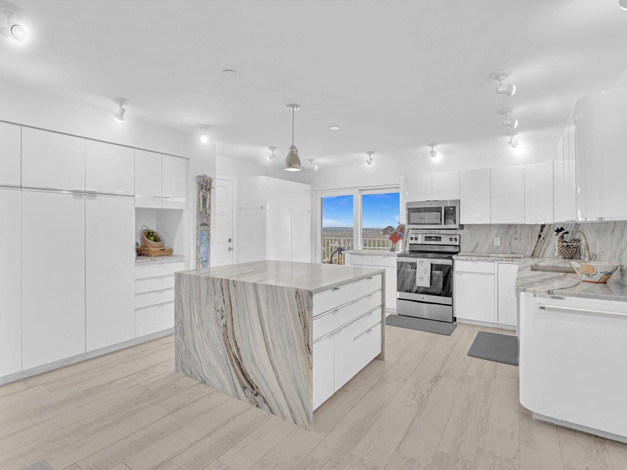 3000 South Ocean Boulevard, Unit 1504 Boca Raton, FL 33432 - Photo 10 of 64 a kitchen with white cabinets and stainless steel appliances