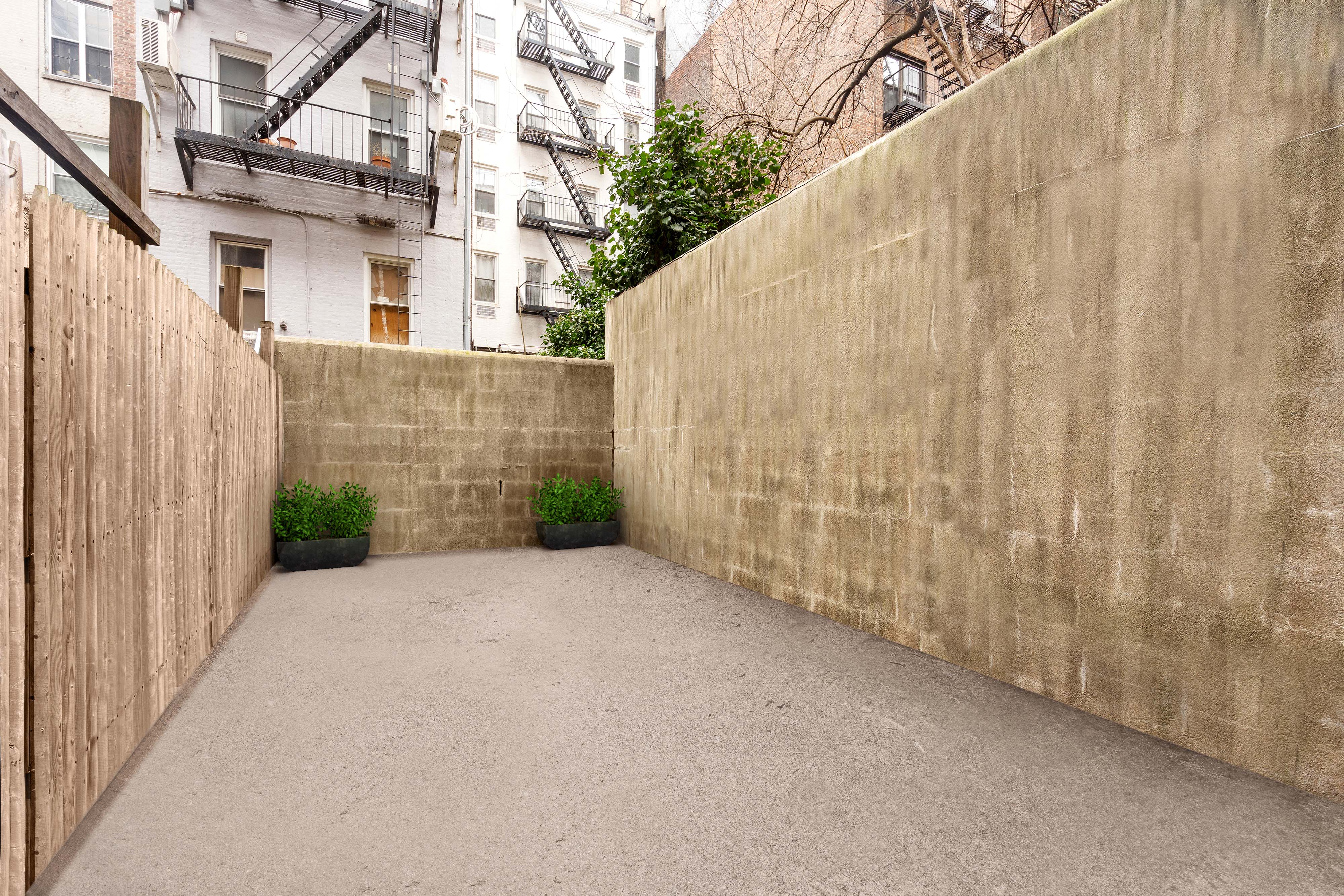 343 East 76th Street, Unit ABC Manhattan, NY 10021 - Photo 4 of 9 a view of a back yard with brick wall and fence
