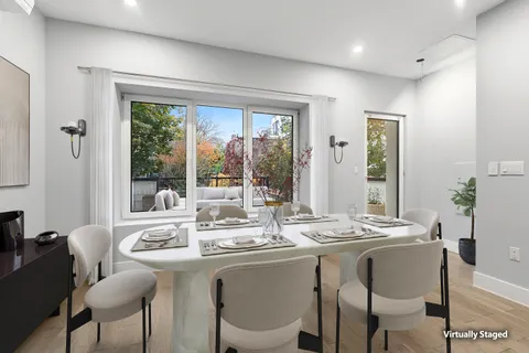a dining room with furniture a large window and a chandelier