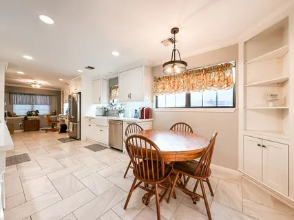 a dining room filled chandelier and kitchen view