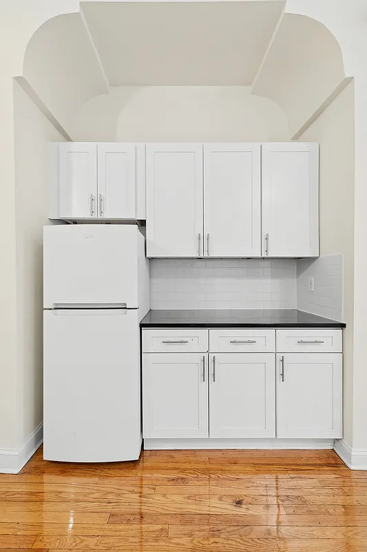 1102 Dean Street, Unit 4 Brooklyn, NY 11216 - Photo 10 of 12 a kitchen with granite countertop cabinets and white appliances