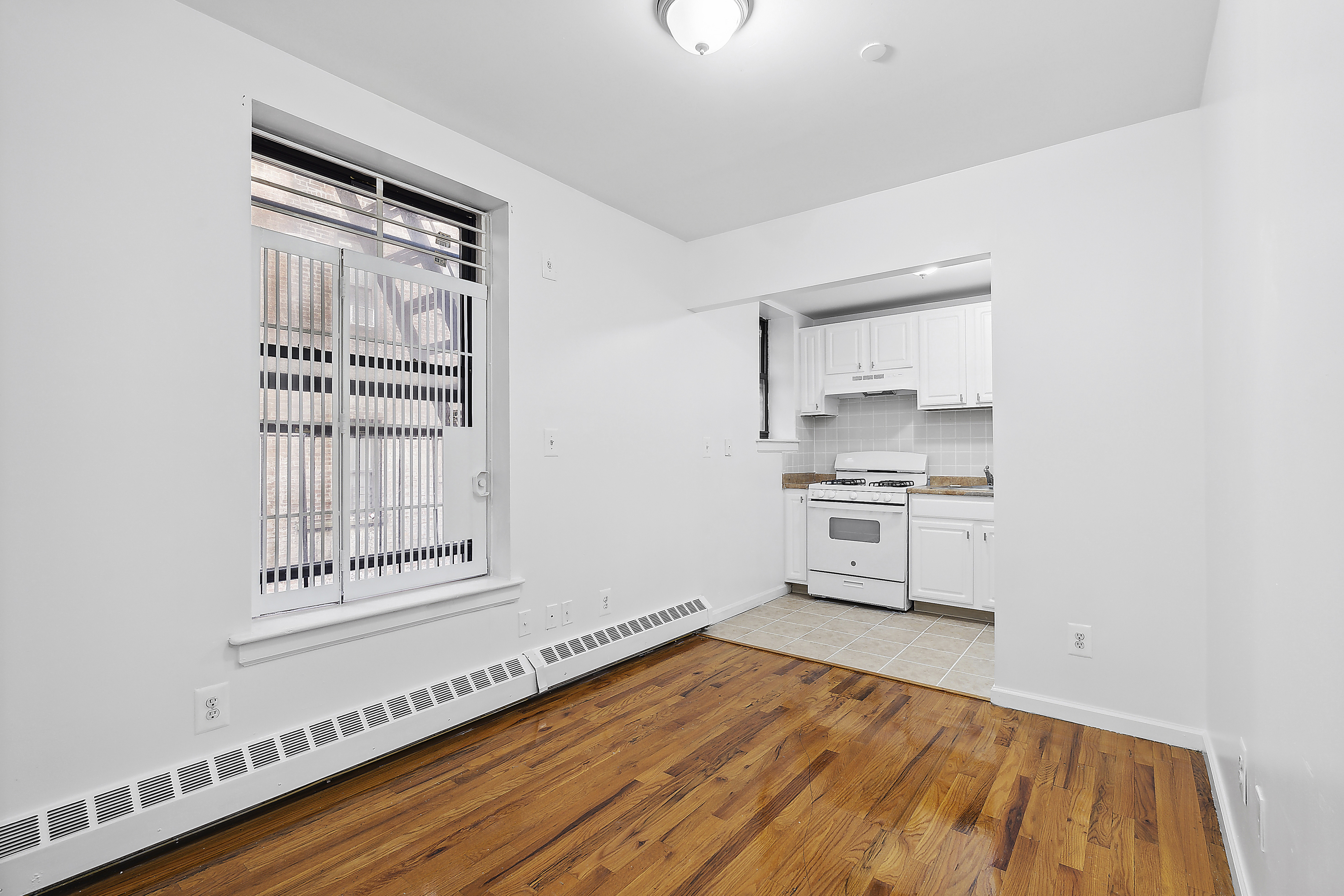 660 St Nicholas Avenue, Unit 33 Manhattan, NY 10030 - Photo 5 of 11 a view of a kitchen with wooden floor and electronic appliances