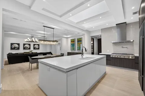 a large white kitchen with a stove a sink a refrigerator and a refrigerator