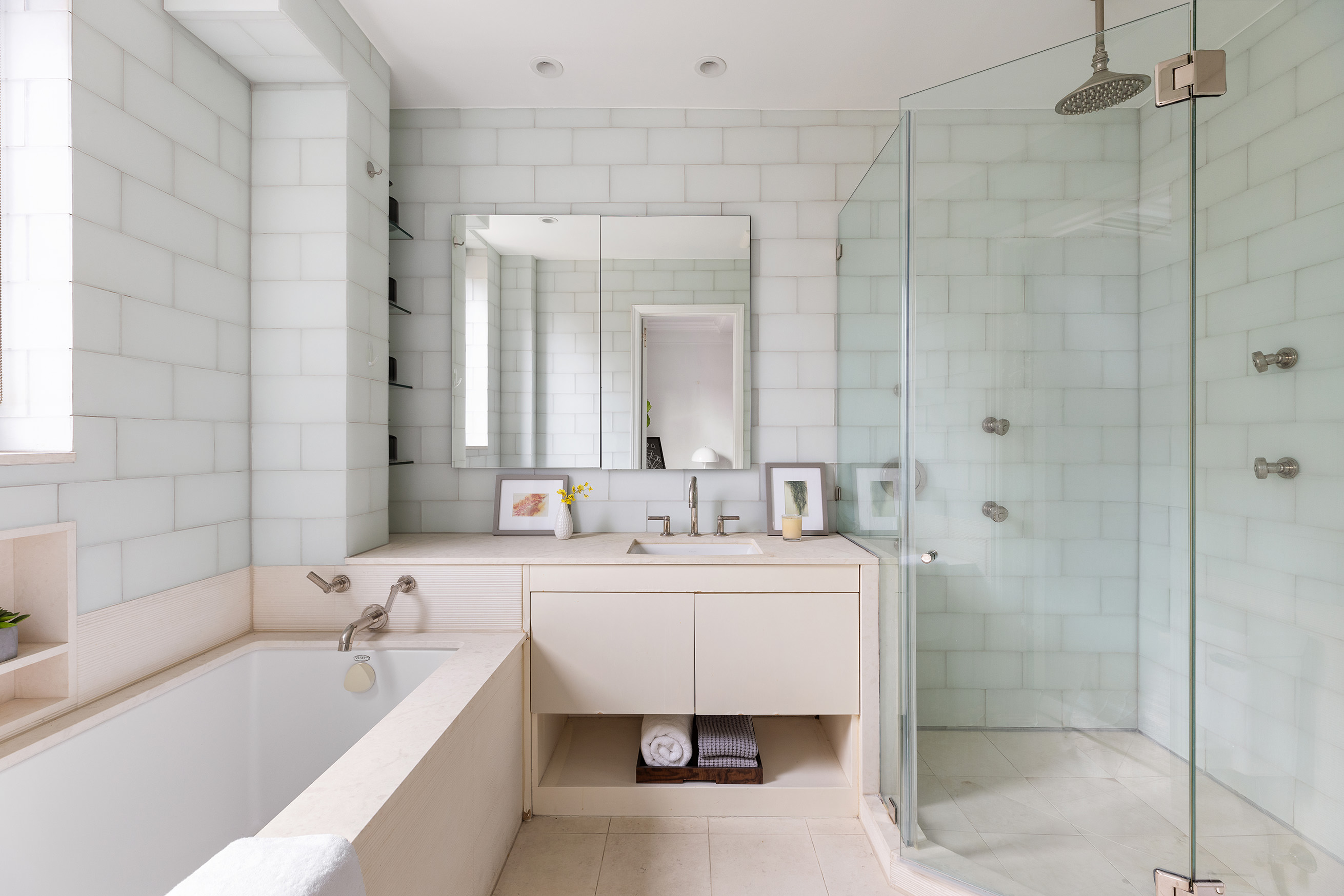 180 East 79th Street, Unit 14G Manhattan, NY 10075 - Photo 6 of 12 a bathroom with a double vanity sink mirror and bathtub
