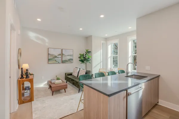 a room with kitchen island stainless steel appliances a table and chairs in it
