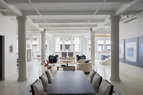 a living room with furniture large window and wooden floor