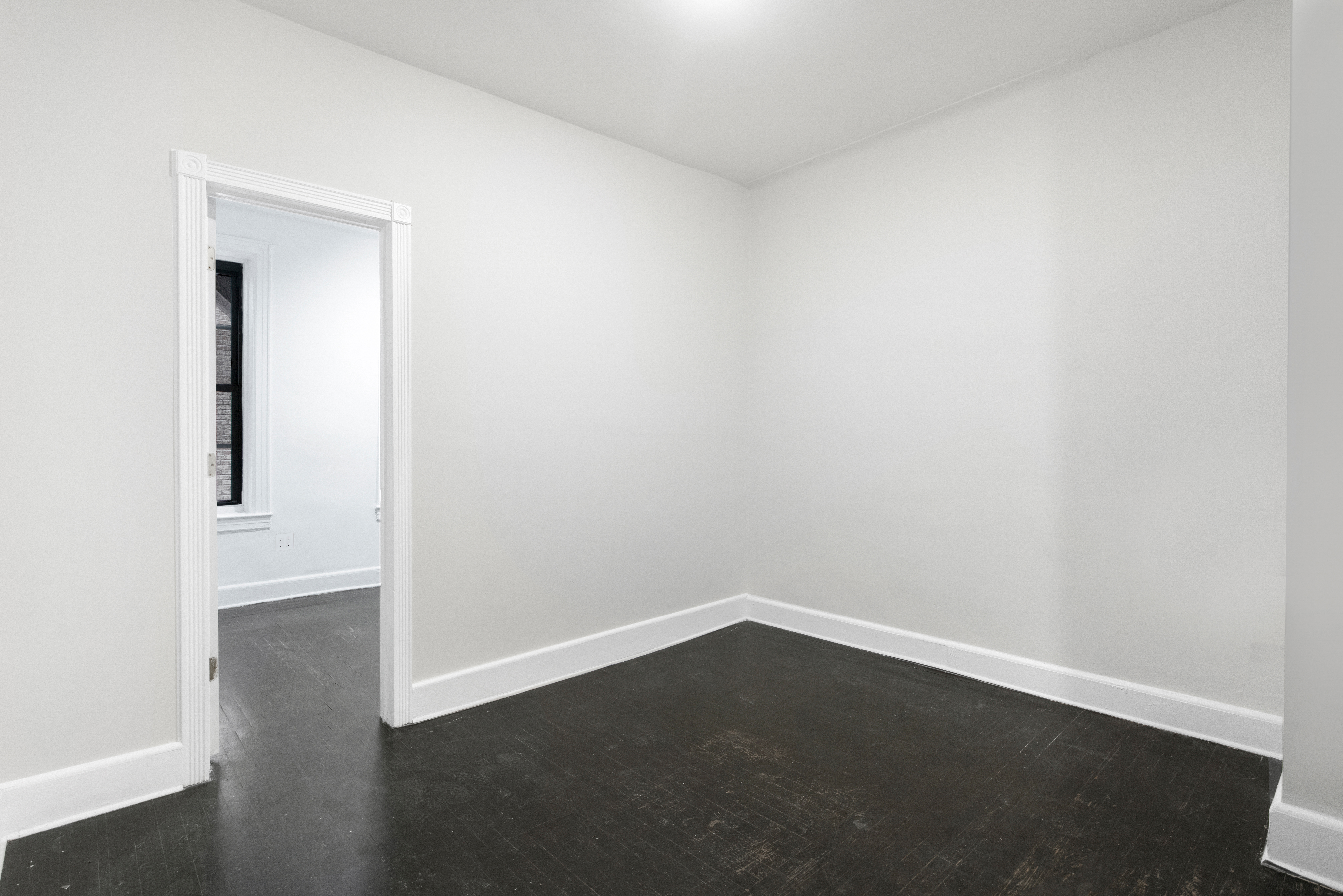 1605 York Avenue, Unit 1A Manhattan, NY 10028 - Photo 4 of 8 an empty room with wooden floor and windows