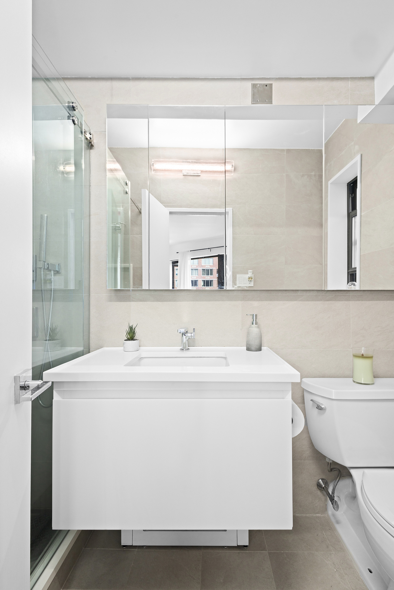 240 East 46th Street, Unit PHC Manhattan, NY 10017 - Photo 6 of 6 a bathroom with a sink a toilet a mirror and a shower