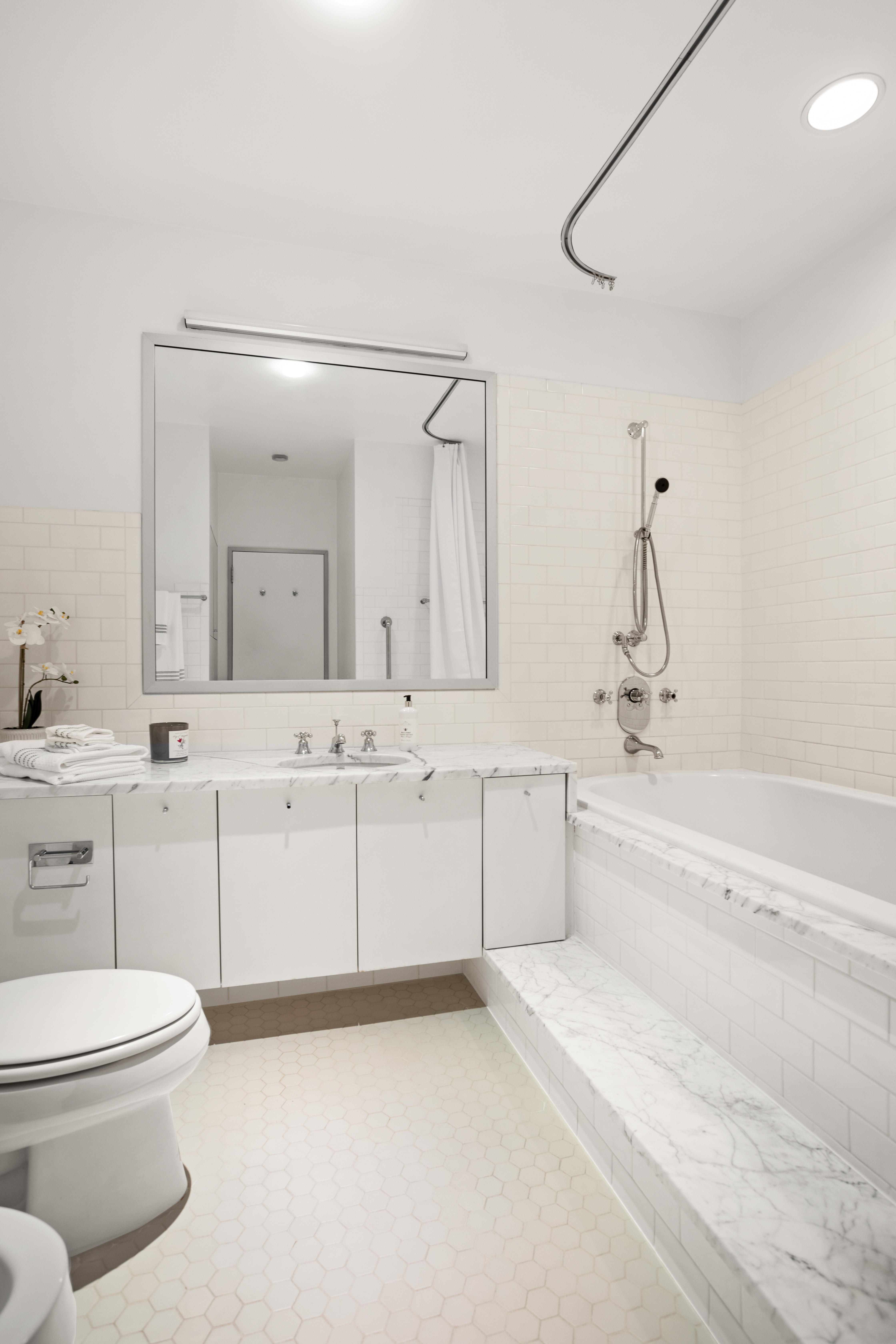 2 5th Avenue, Unit PHDF Manhattan, NY 10011 - Photo 13 of 24 a bathroom with a sink a toilet and a mirror