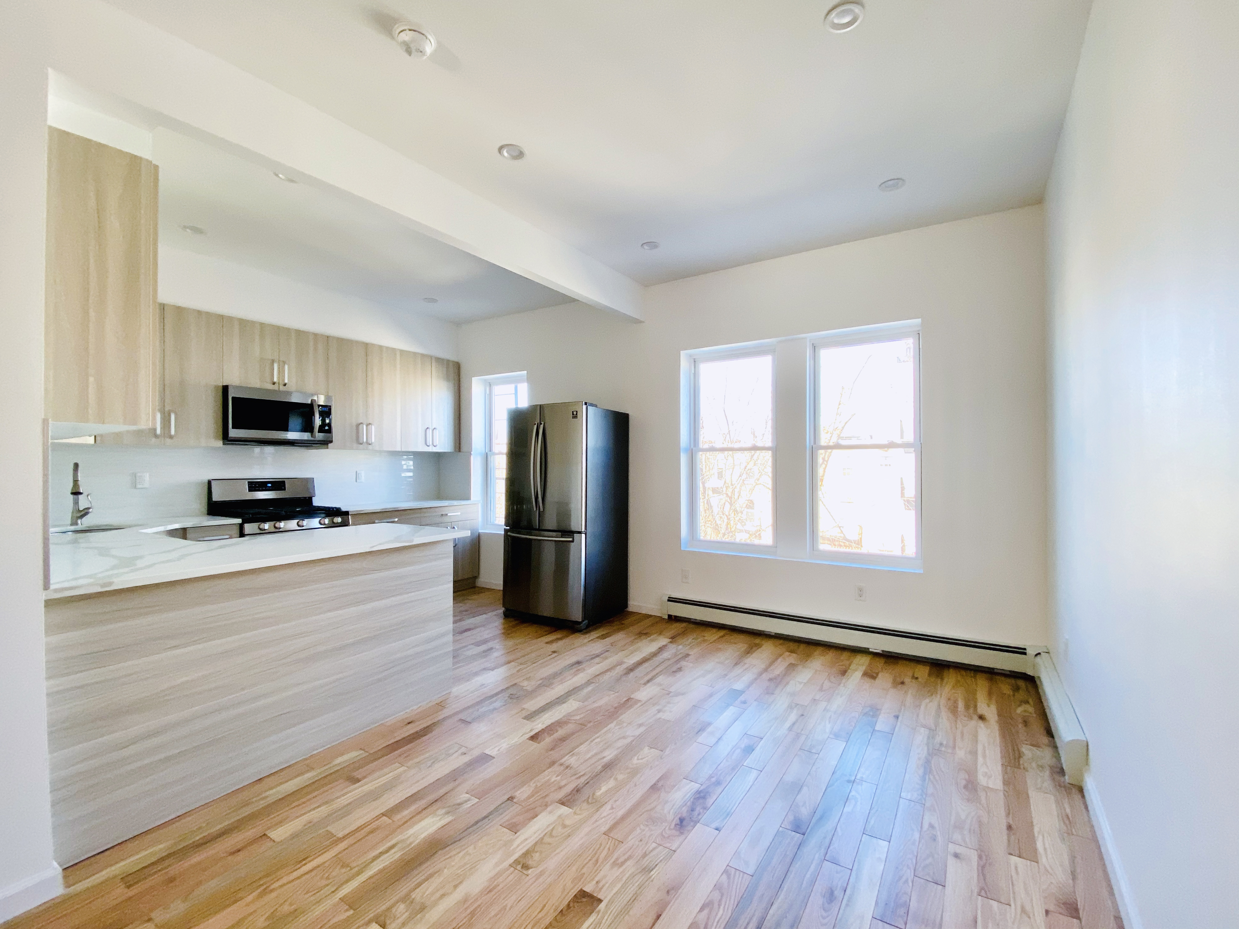 175 Luquer Street, Unit 4 Brooklyn, NY 11231 - Photo 16 of 21 a large kitchen with a large window a refrigerator and a stove top oven