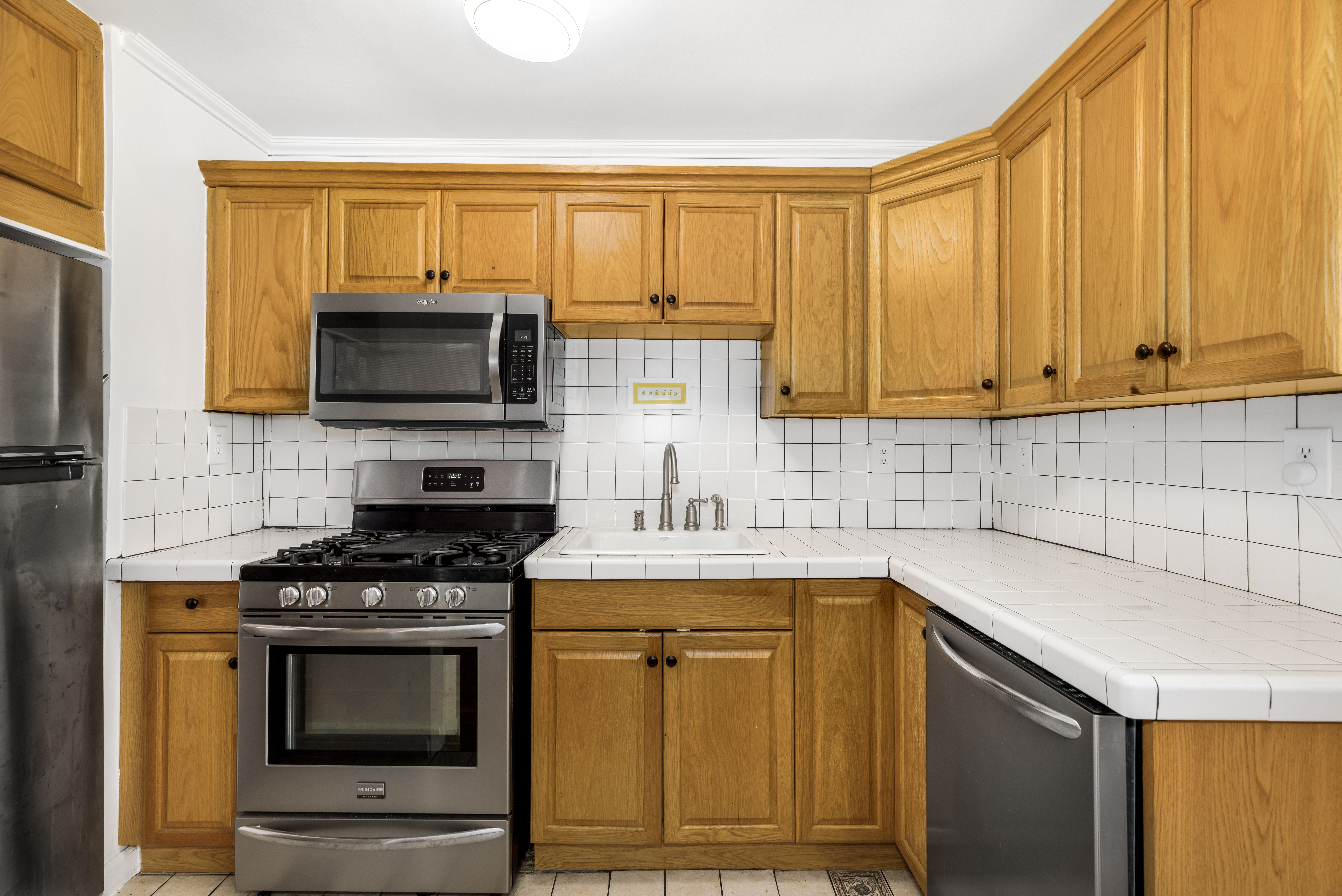 165 Christopher Street, Unit 3A Manhattan, NY 10014 - Photo 5 of 8 a kitchen with granite countertop a stove top oven microwave and cabinets