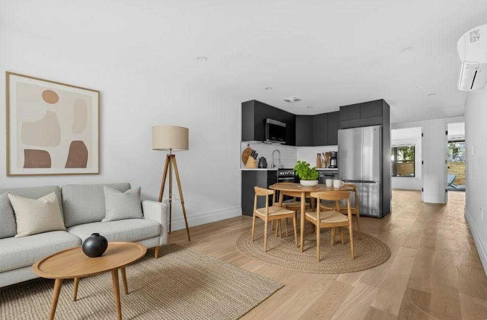 a living room with furniture and a dining table with kitchen view