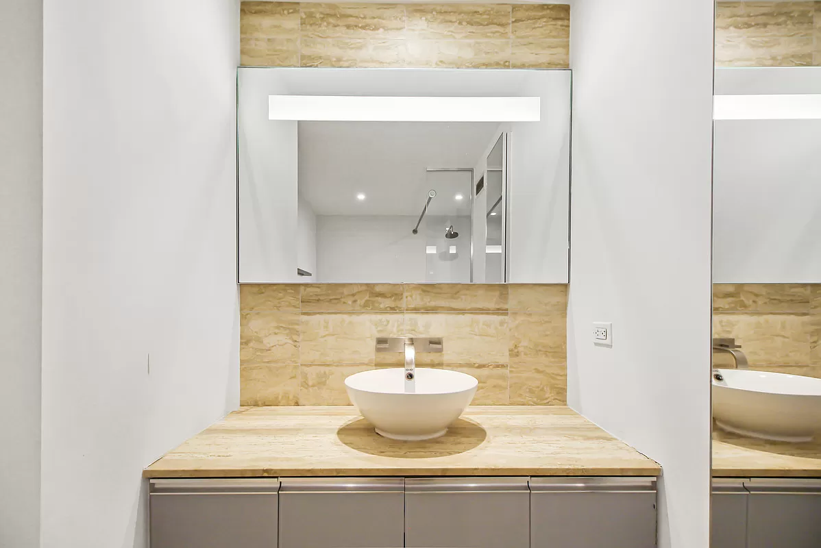 322 West 57th Street, Unit 38Q Manhattan, NY 10019 - Photo 7 of 16 a bathroom with a sink and a mirror