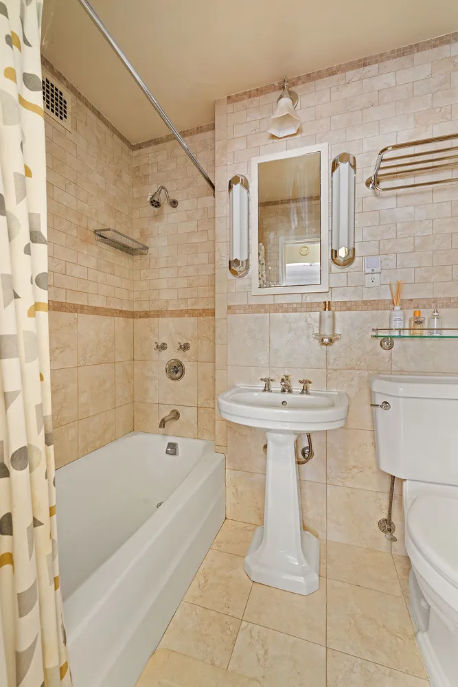 a bathroom with a bathtub shower sink and toilet