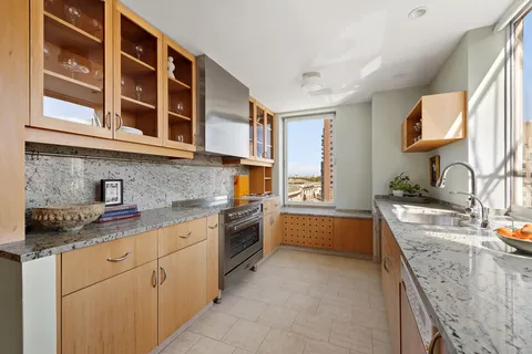 a kitchen with stainless steel appliances granite countertop a sink stove and cabinets