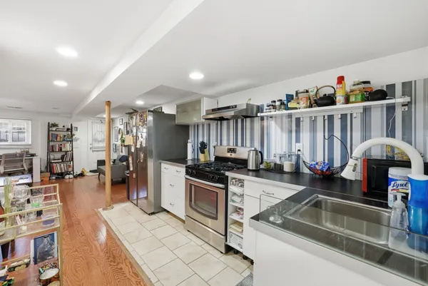 a kitchen with stainless steel appliances granite countertop a sink counter space cabinets and a view of living room