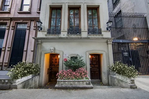front view of a brick house with potted plants