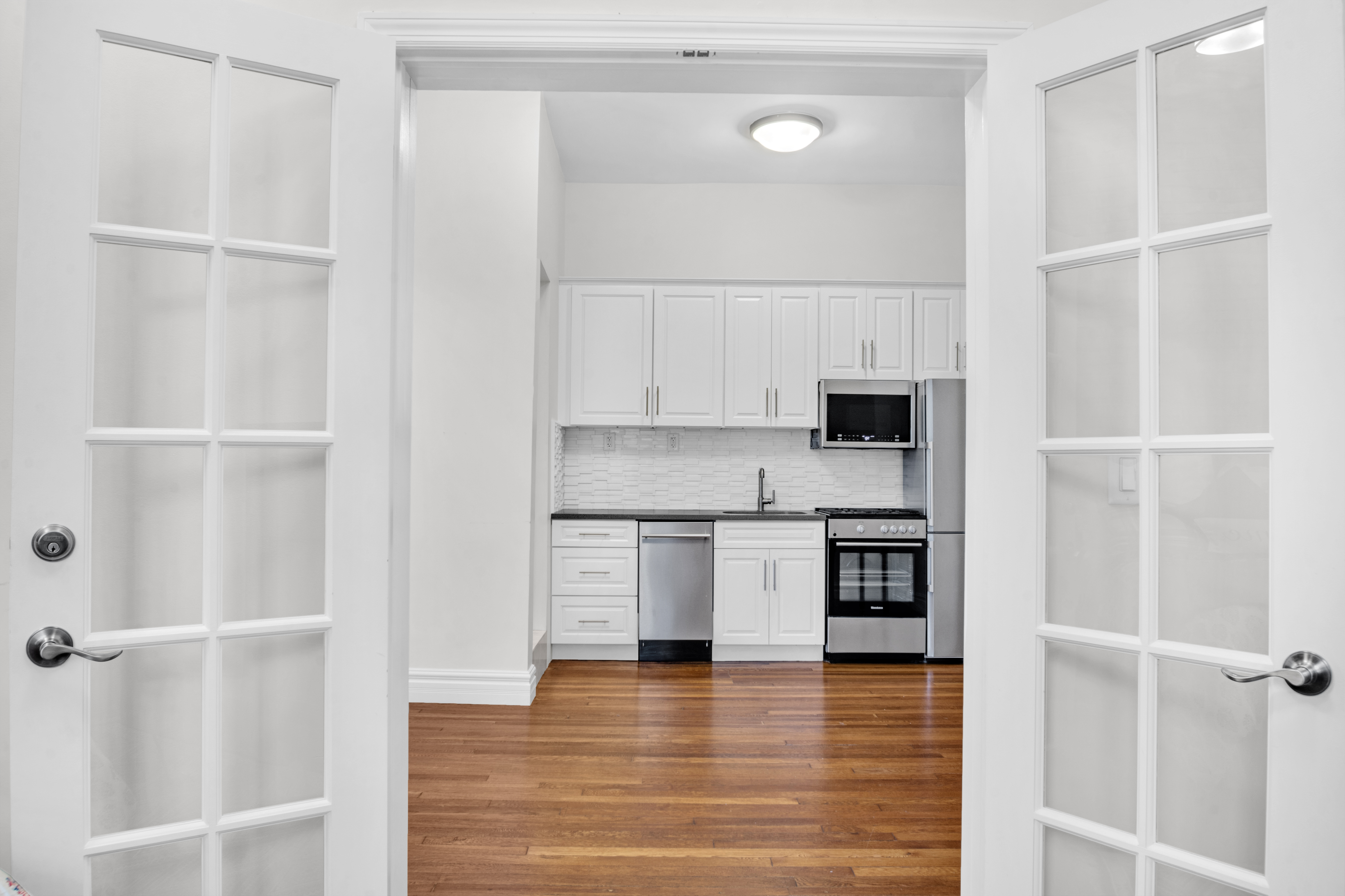 244 Riverside Drive, Unit 2F Manhattan, NY 10025 - Photo 2 of 8 a kitchen with stainless steel appliances granite countertop a refrigerator and a stove top oven