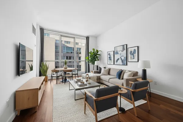a living room with furniture wooden floor and a flat screen tv