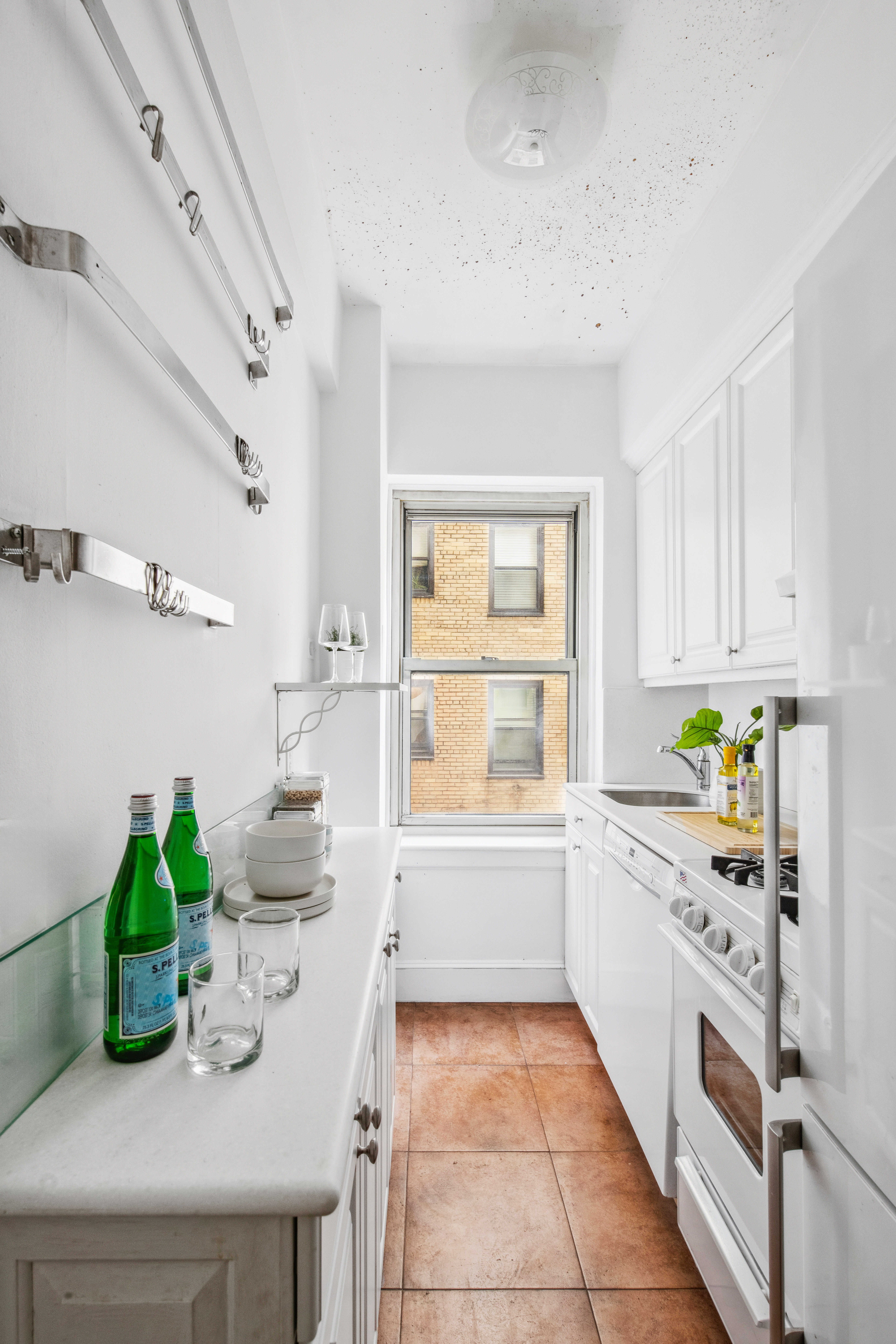 400 East 52nd Street, Unit 6K Manhattan, NY 10022 - Photo 3 of 8 a kitchen with white cabinets and window