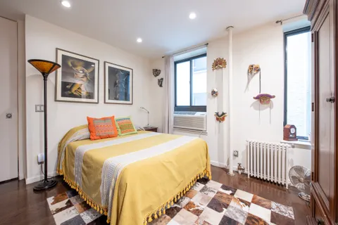 a bedroom with a bed and a painting on the wall