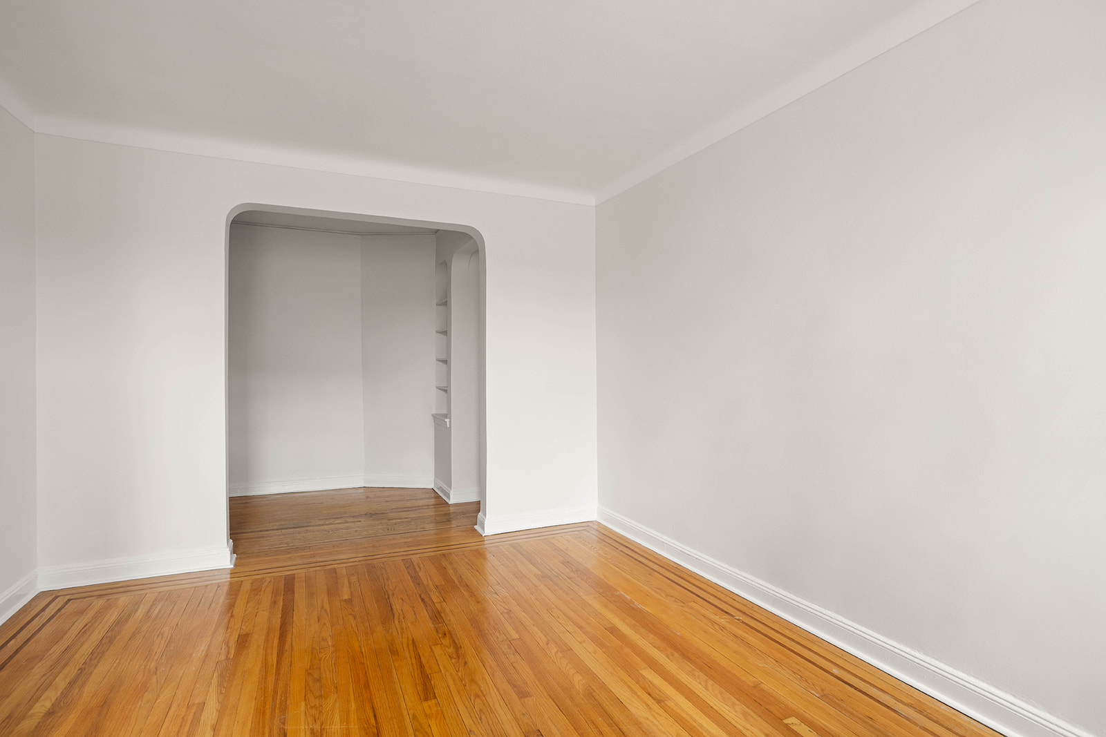 76-12 35th Avenue, Unit 6J Queens, NY 11372 - Photo 6 of 17 a view of an empty room with wooden floor