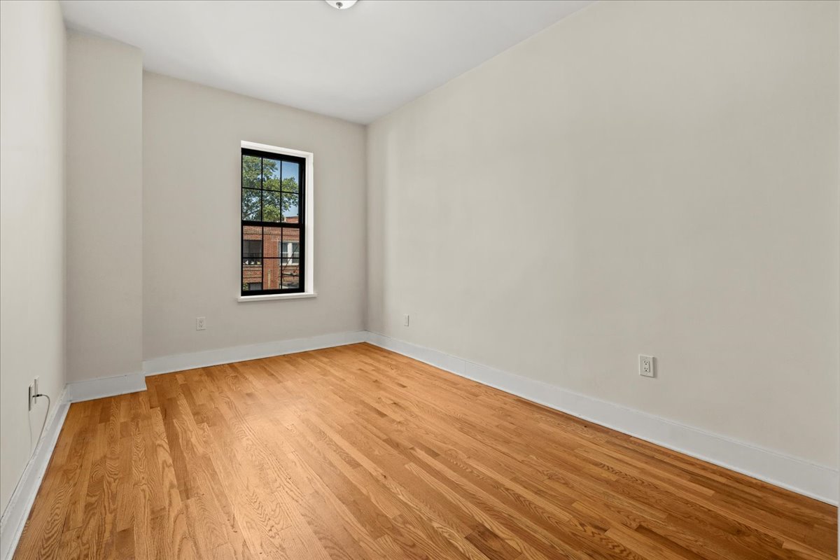 1773 Nostrand Avenue Brooklyn, NY 11226 - Photo 6 of 12 a view of an empty room with wooden floor and a window