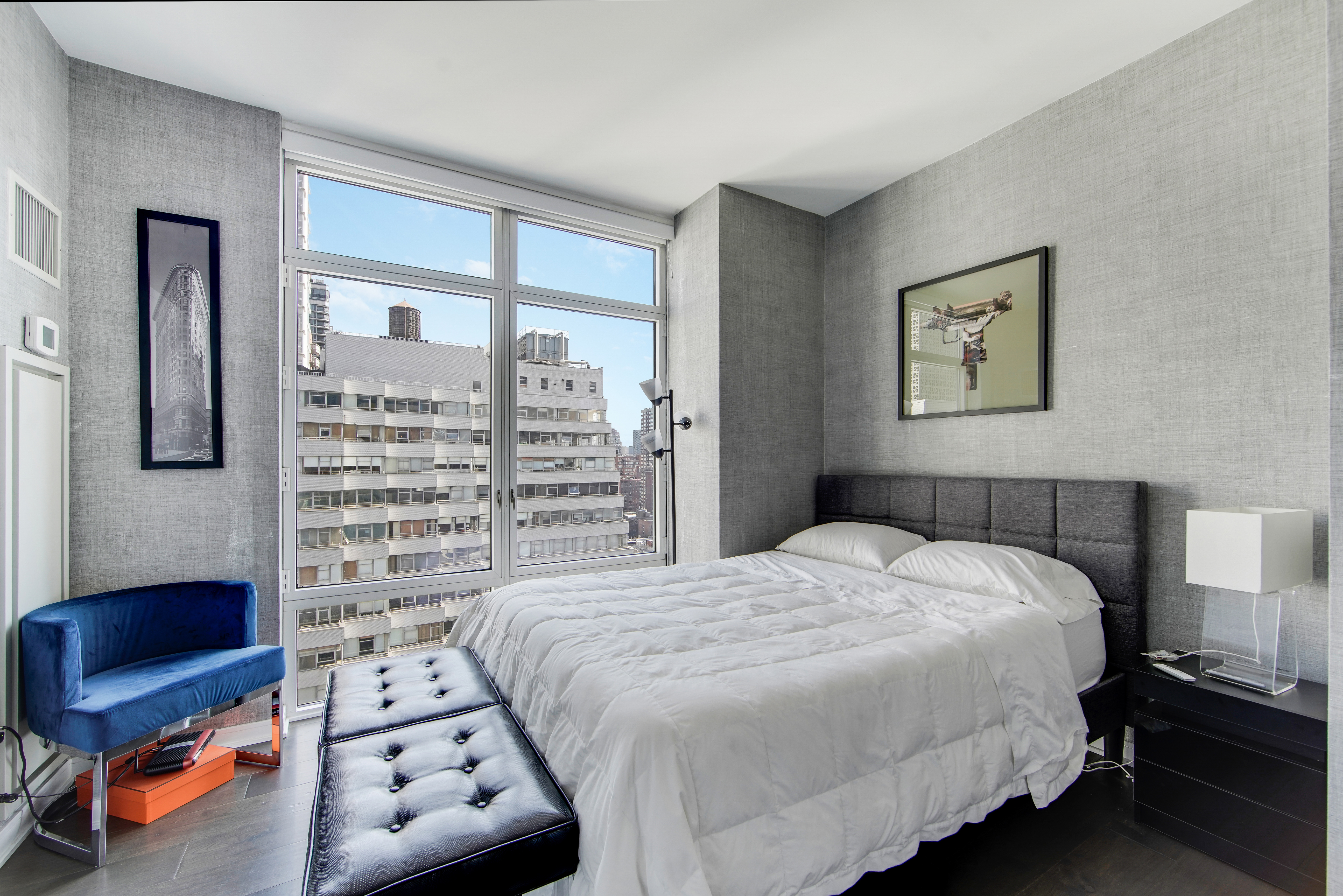 207 East 57th Street, Unit 20A Manhattan, NY 10022 - Photo 11 of 18 a bedroom with a bed and a lamp on the dresser