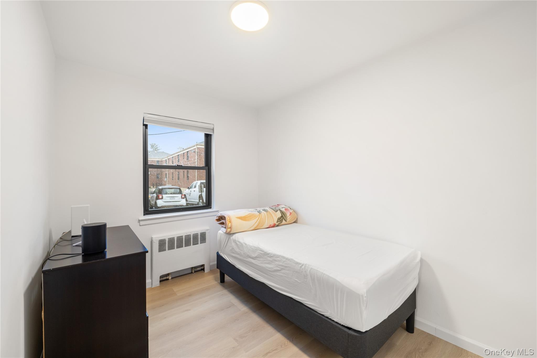 217-14 73rd Avenue, Unit 1 Queens, NY 11364 - Photo 14 of 19 a bedroom with a bed and a window