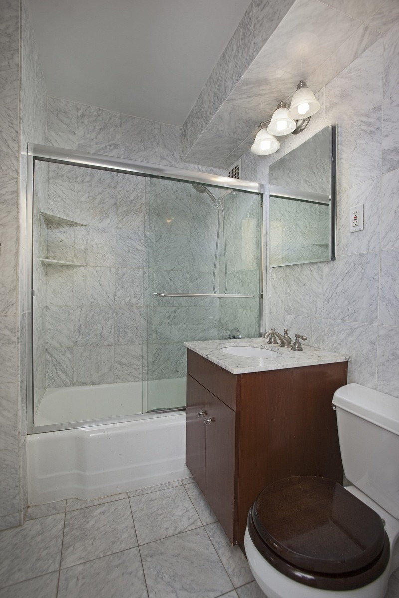 320 East 54th Street, Unit 8B Manhattan, NY 10022 - Photo 5 of 6 a bathroom with a sink a toilet and shower