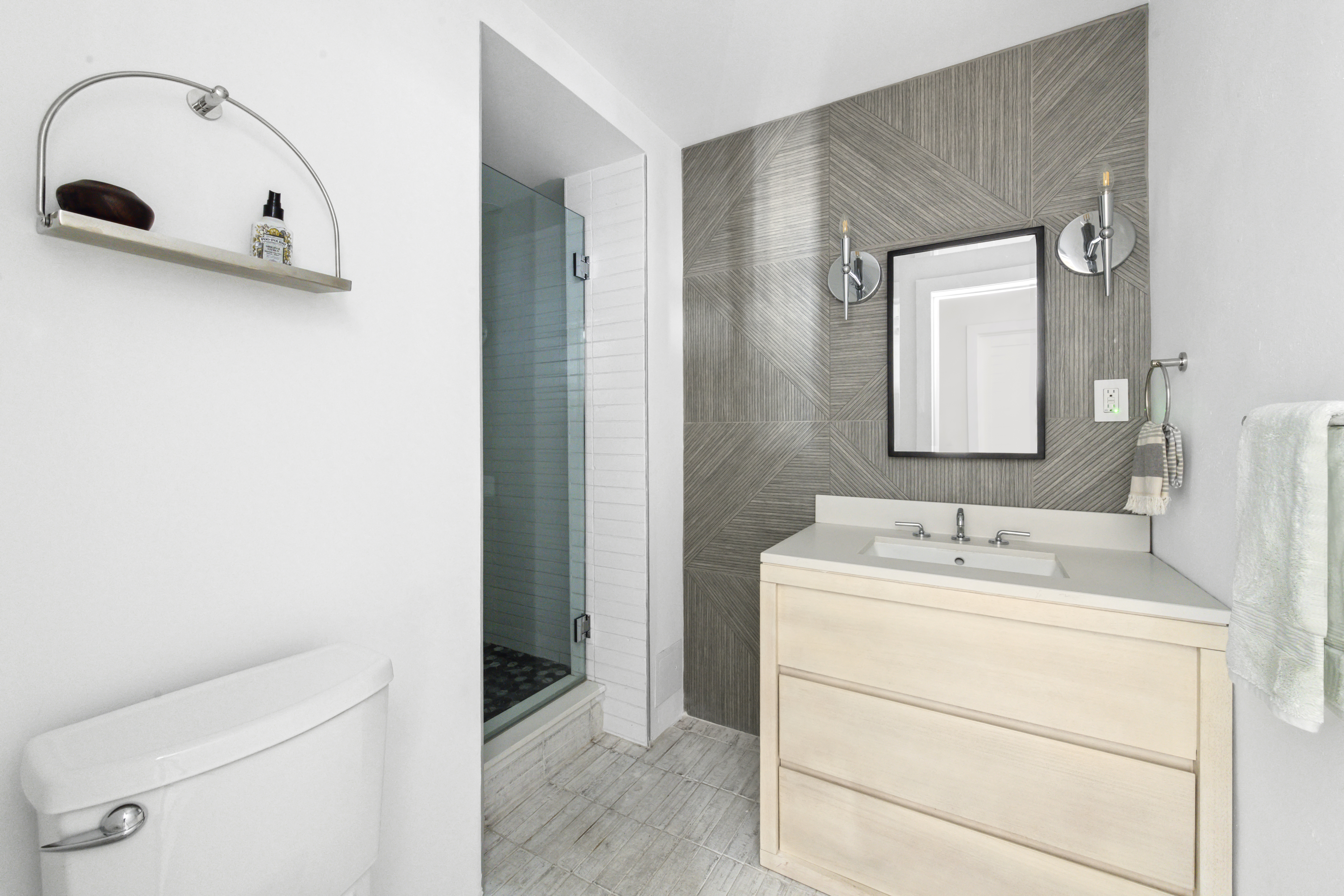 225 East 57th Street, Unit 14E Manhattan, NY 10022 - Photo 9 of 10 a bathroom with a sink a toilet and mirror