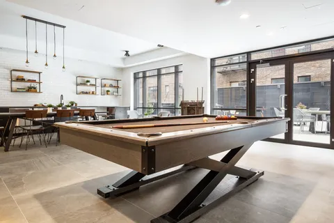a living room with windows pool table and a large window