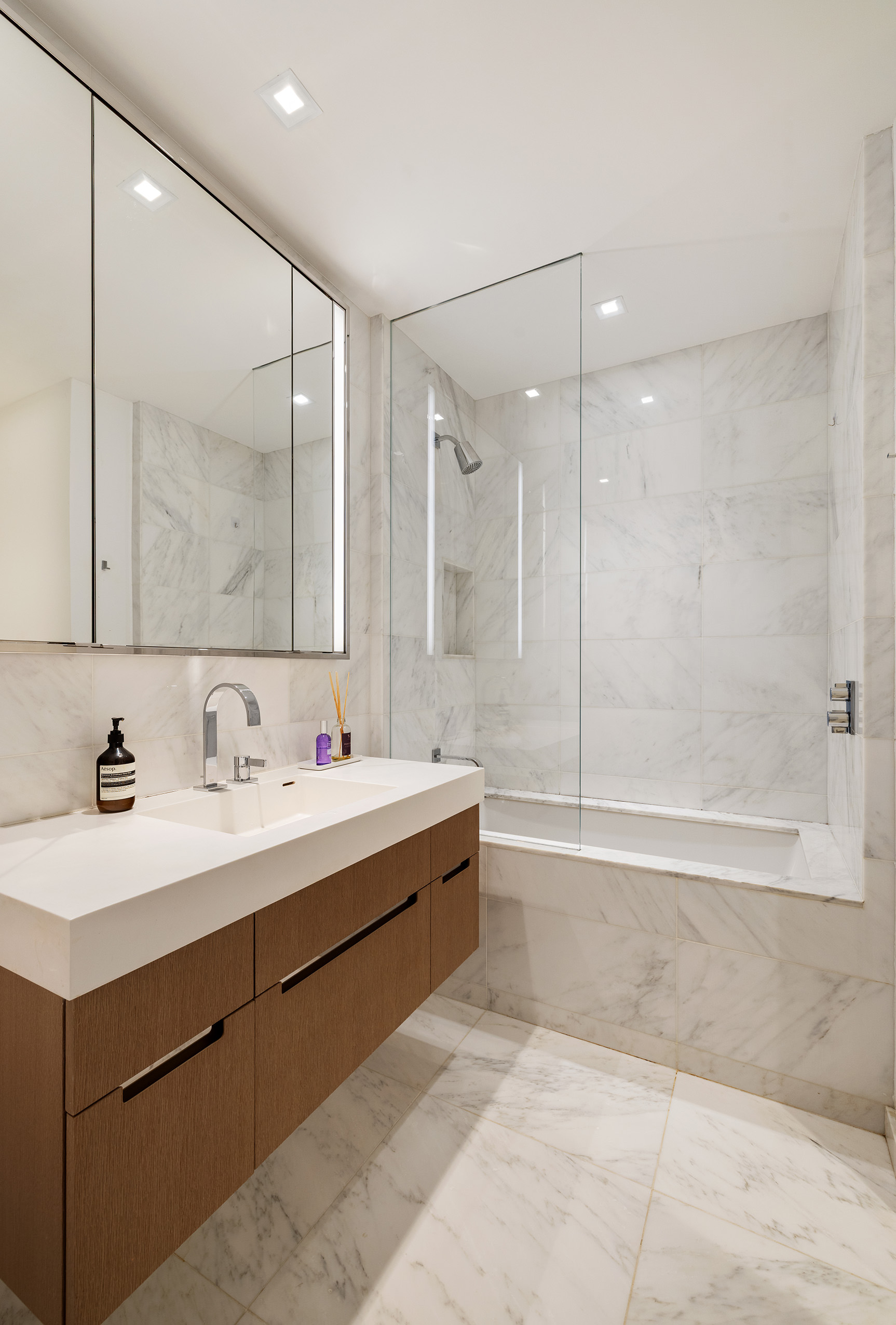 1 West End Avenue, Unit 25F Manhattan, NY 10023 - Photo 9 of 15 a bathroom with a bathtub shower sink and mirror