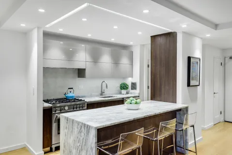 a kitchen with stainless steel appliances kitchen island granite countertop a table chairs stove and cabinets