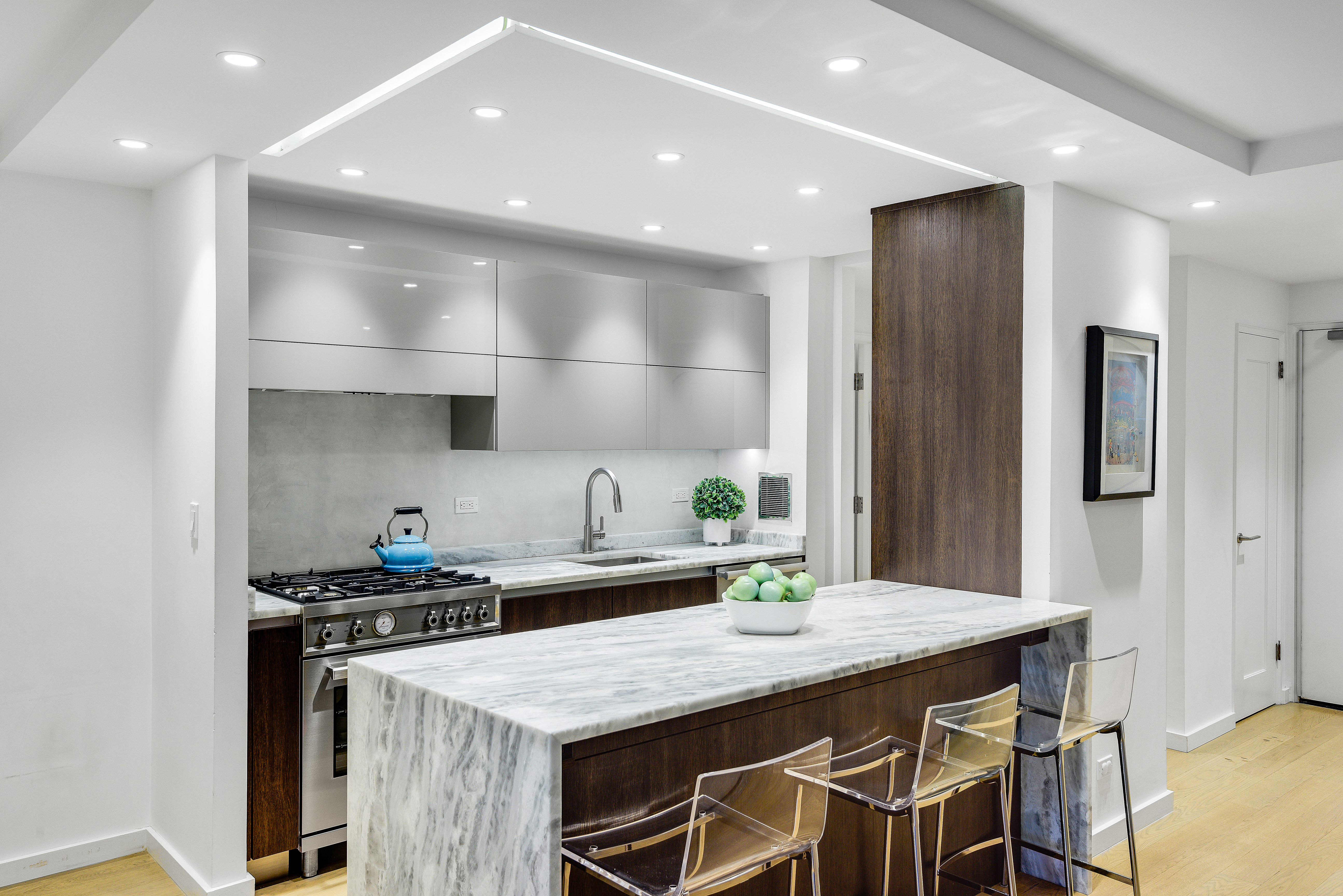 200 Central Park South, Unit 3Q Manhattan, NY 10019 - Photo 5 of 15 a kitchen with stainless steel appliances kitchen island granite countertop a table chairs stove and cabinets