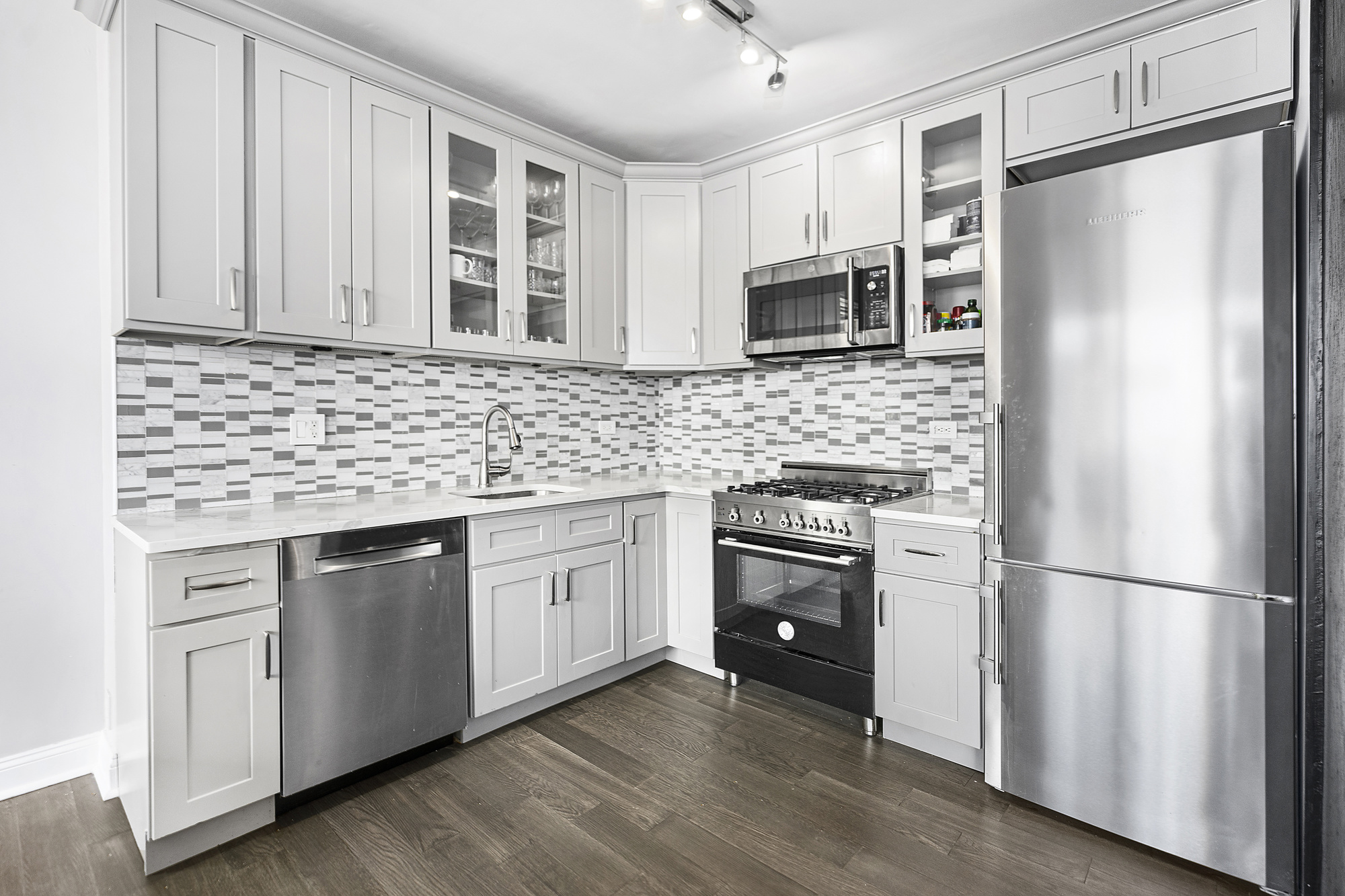 418 East 59th Street, Unit 35A Manhattan, NY 10022 - Photo 3 of 7 a kitchen with stainless steel appliances granite countertop a refrigerator sink and microwave